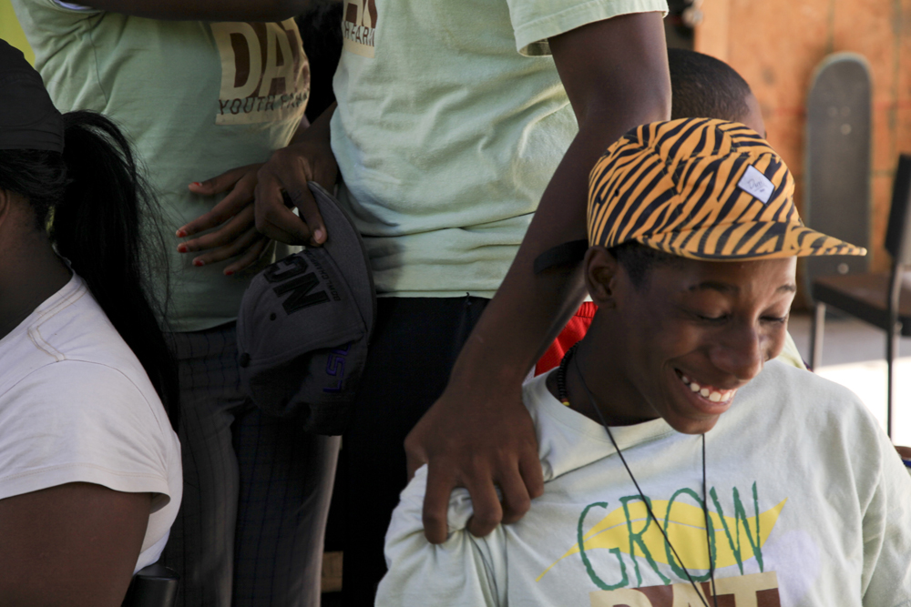 A smile stretches across Devon Coakley's face as his fellow Grow Dat team member Shawn Dexter offers a compliment through a tight shoulder grip during a confidence builder activity. Dexter's gesture informed Coakley that his humor does not go unnoticed at the farm. NYT Institute I Dacia Idom